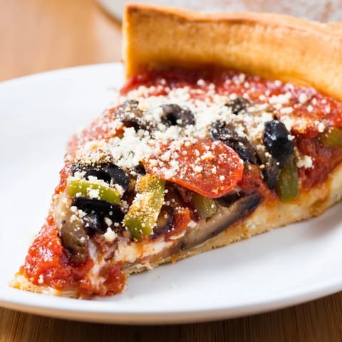 Close-up photo of a Chicago-style deep dish pizza topped with pepperoni and flavorful sauce.