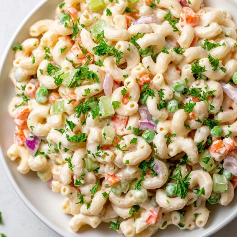 Close-up of classic American macaroni salad, showcasing the creamy dressing and fresh ingredients.