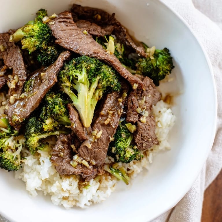 Enjoy a flavorful plate of homemade Beef and Broccoli, served atop fluffy, white rice right away.